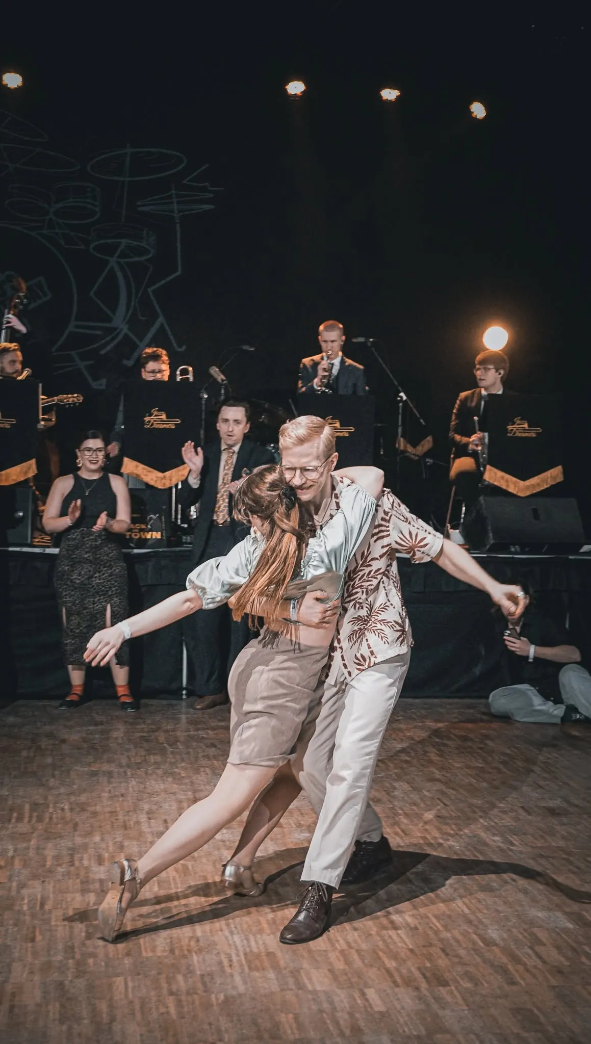 Para tańcząca lindy hopa przed orkiestrą